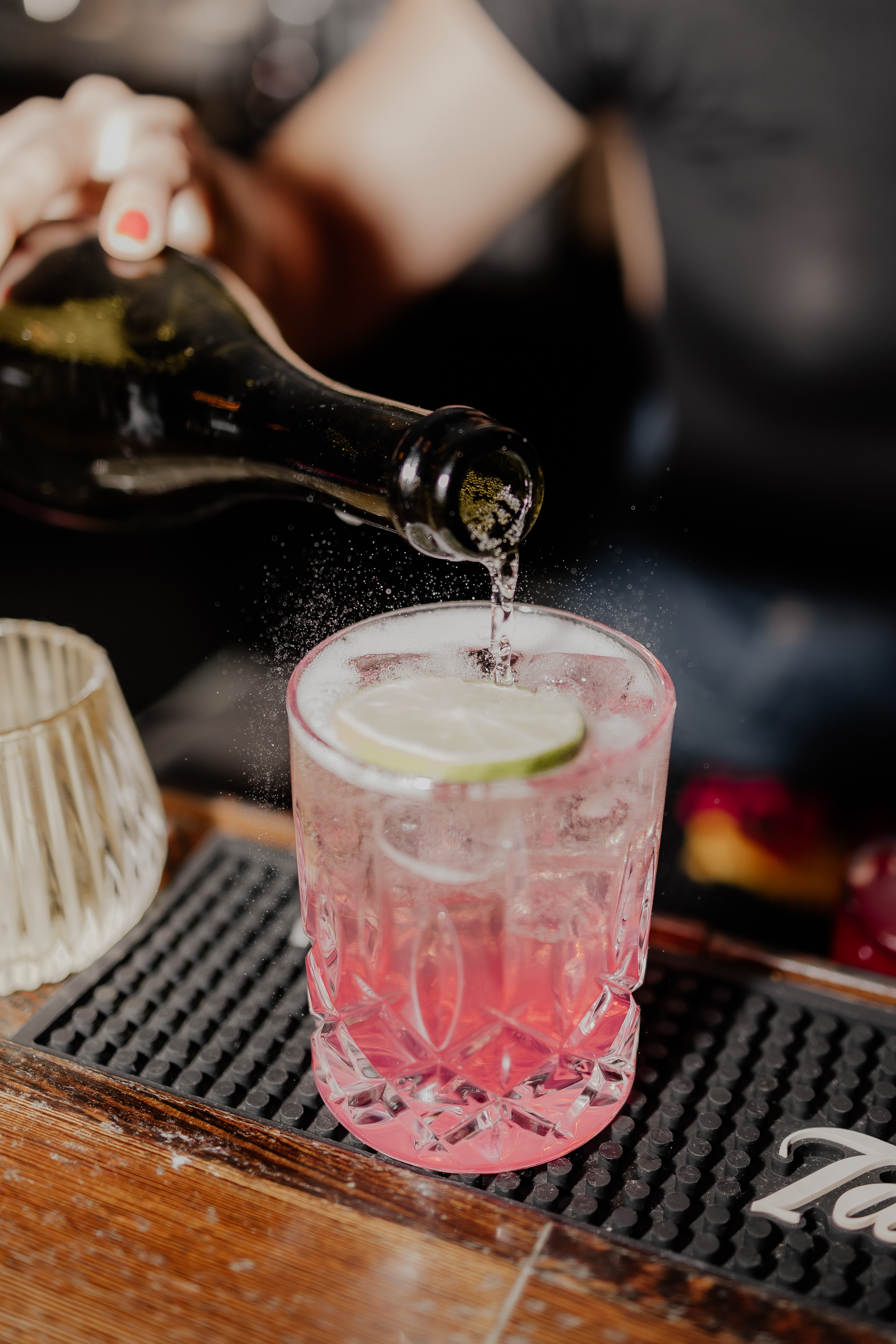 Cocktail wird an der Bar in ein Glas eingeschenkt